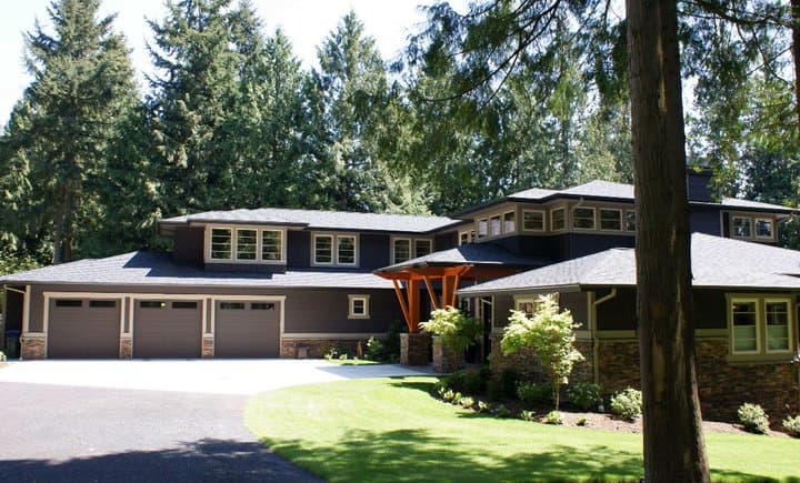 Modern house plan exterior with a three-car garage, layered rooflines, and extensive window bands.