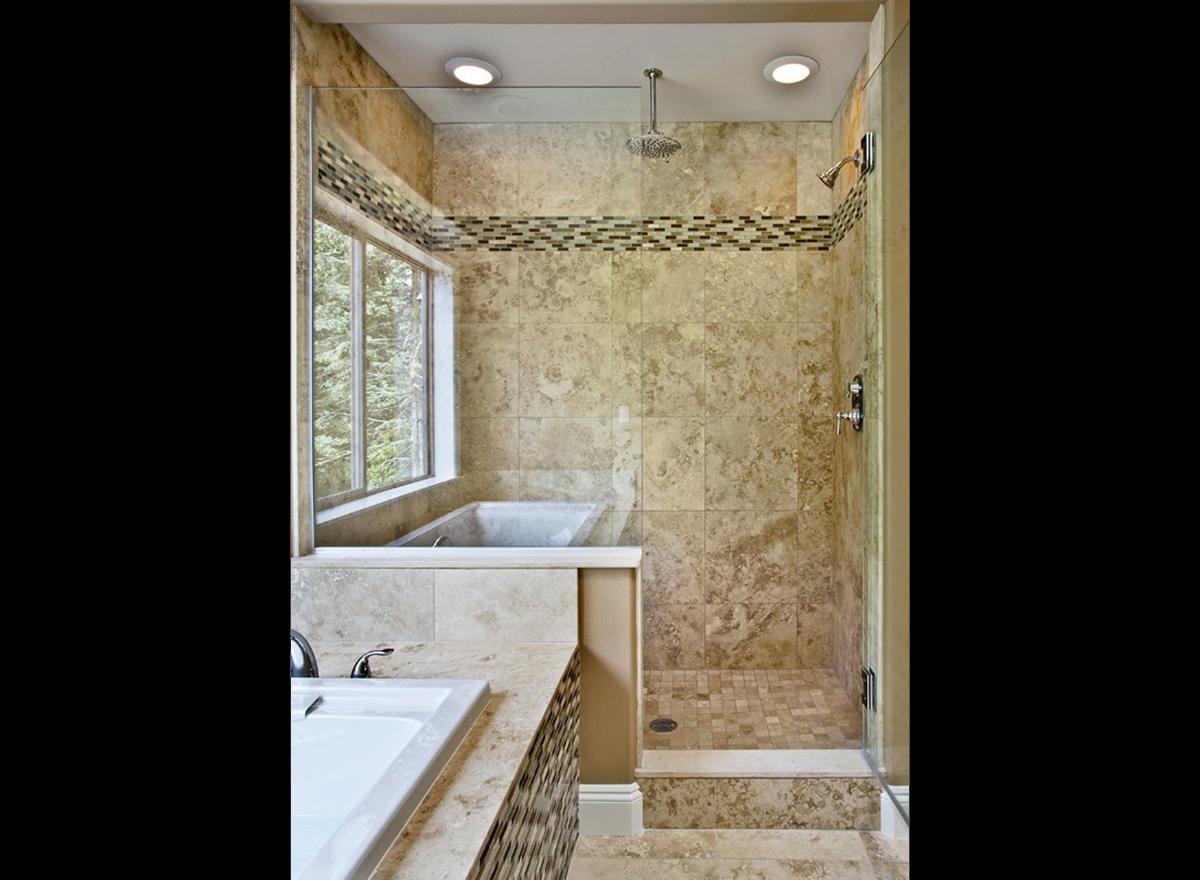 Bathroom with freestanding tub, walk-in shower with dual showerheads, and marble tile finishes.