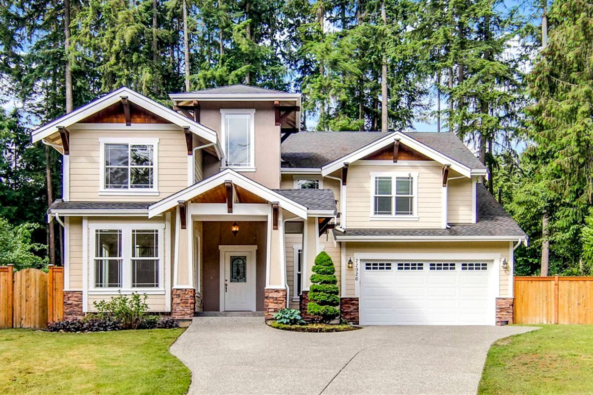 House plan exterior with Craftsman style, two stories, front-facing gables, prominent porch, and a side-entry garage.