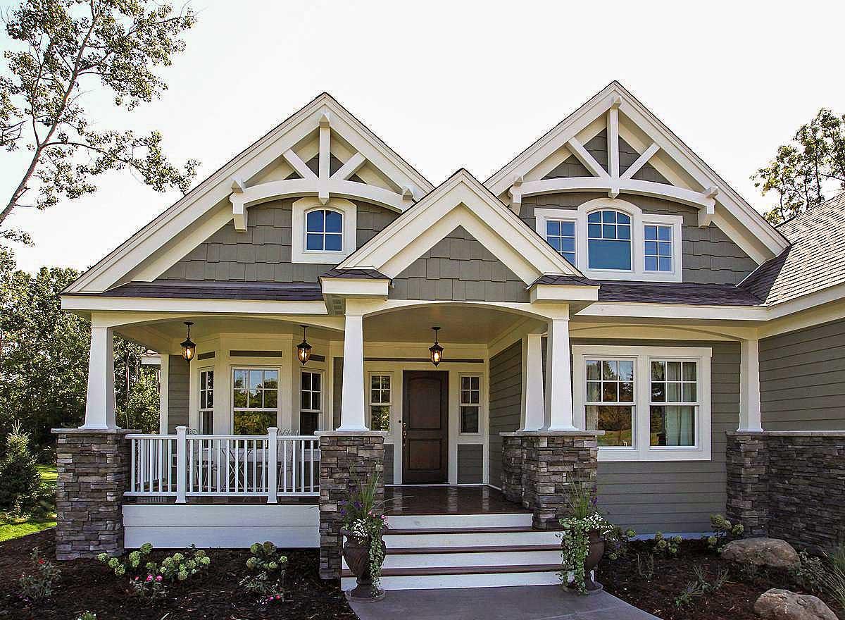 Craftsman style house plan exterior with covered porch, stone column bases, decorative gables, and multi-pane windows.