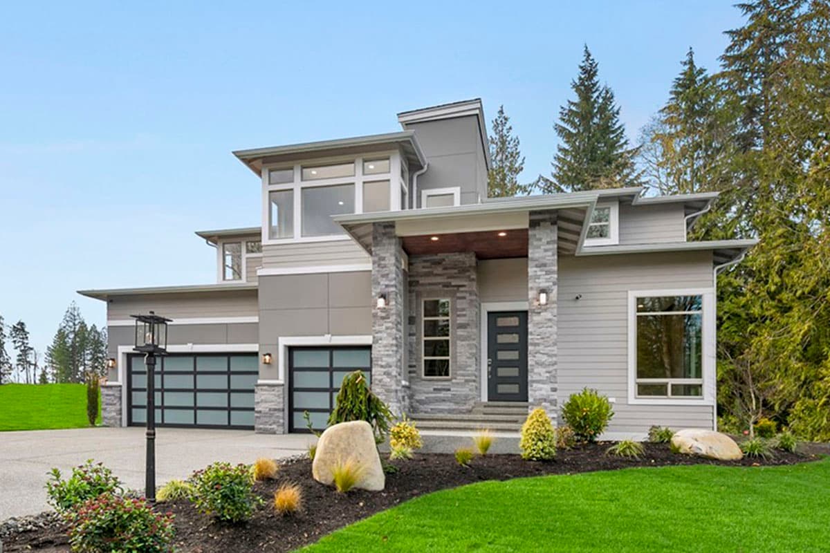 Modern house plan exterior with two stories, a stone-clad entry, flat rooflines, and a three-car garage.