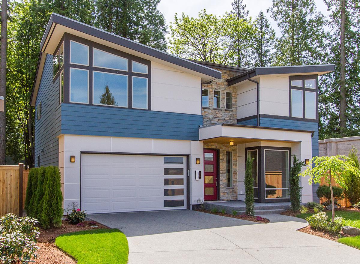 Modern house plan exterior with geometric rooflines, horizontal siding, large windows, and a prominent garage.