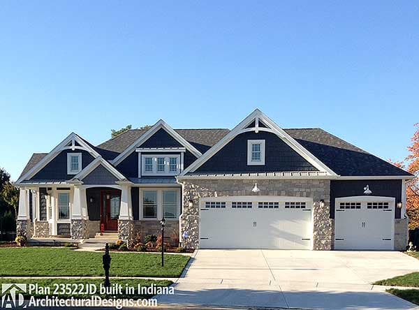 House plan exterior: Craftsman style, two stories, stone accents, prominent gables with decorative brackets, and a three-car garage.