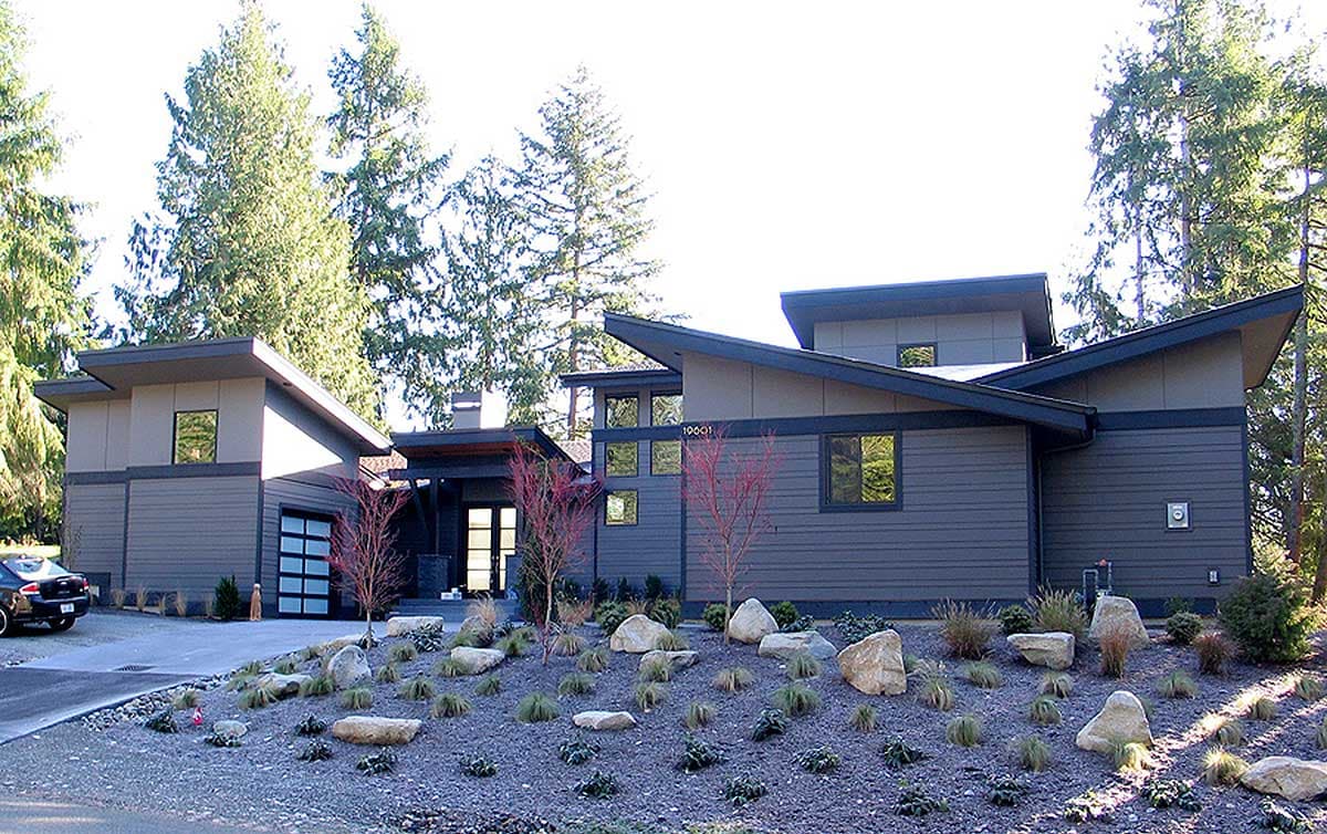 Modern house plan exterior featuring angled rooflines, a two-car garage with glass doors, and extensive use of horizontal siding.
