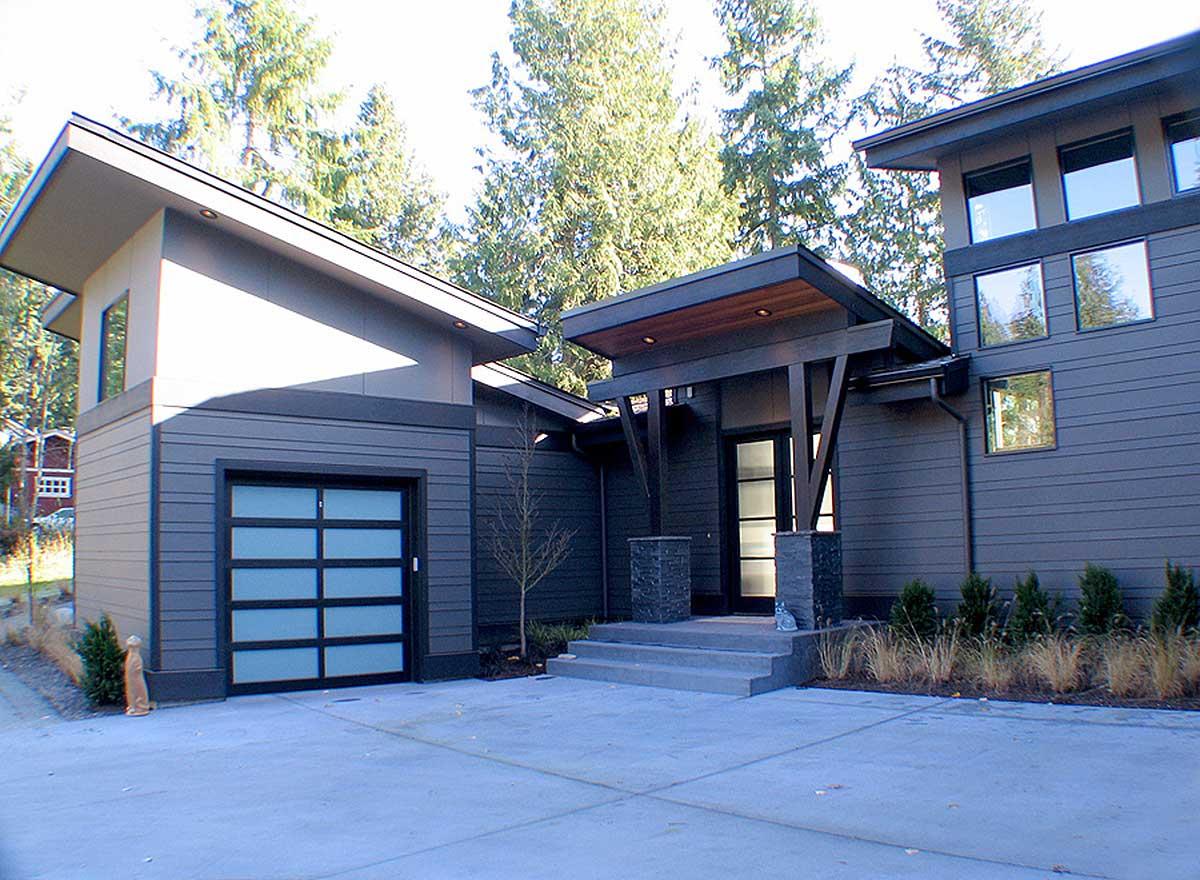 Modern house plan exterior with a two-car garage, cantilevered rooflines, and expansive windows.