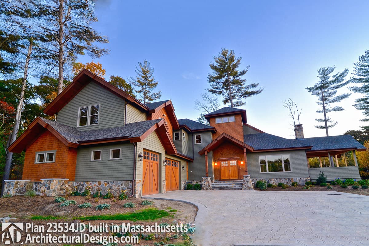 House plan exterior shows a multi-story home with shingle siding, stone accents, gabled dormers, and a three-car garage.