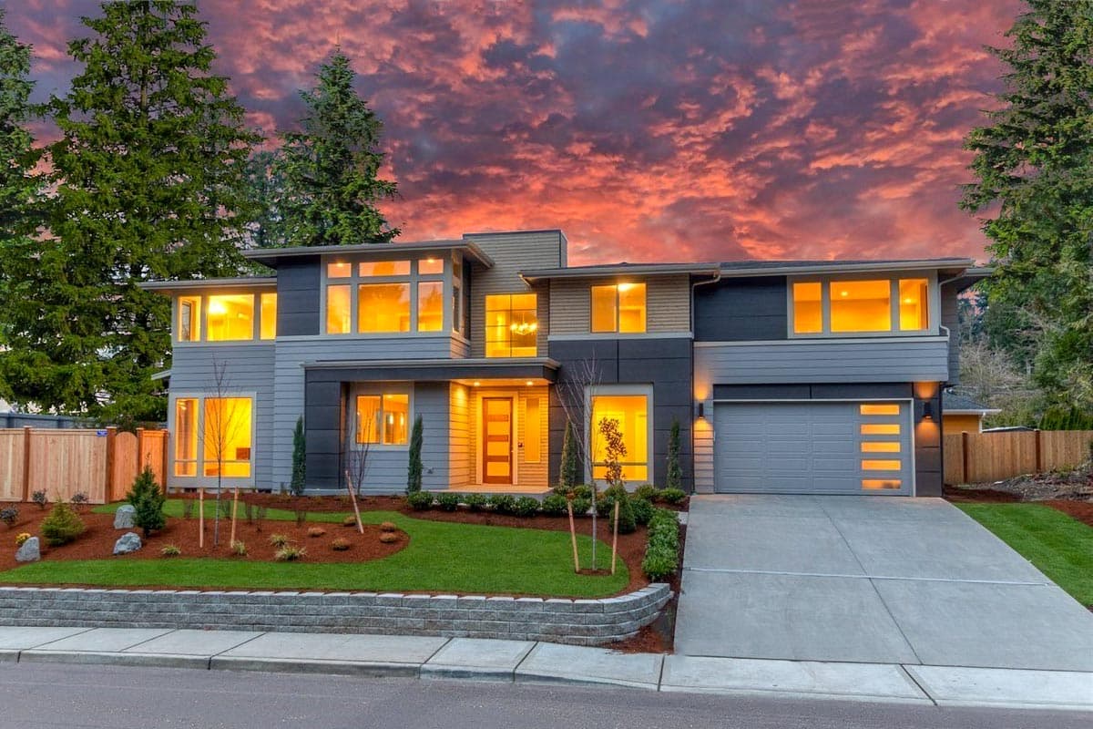 Modern house plan exterior with two stories, a two-car garage, multiple large windows, and a flat roofline.