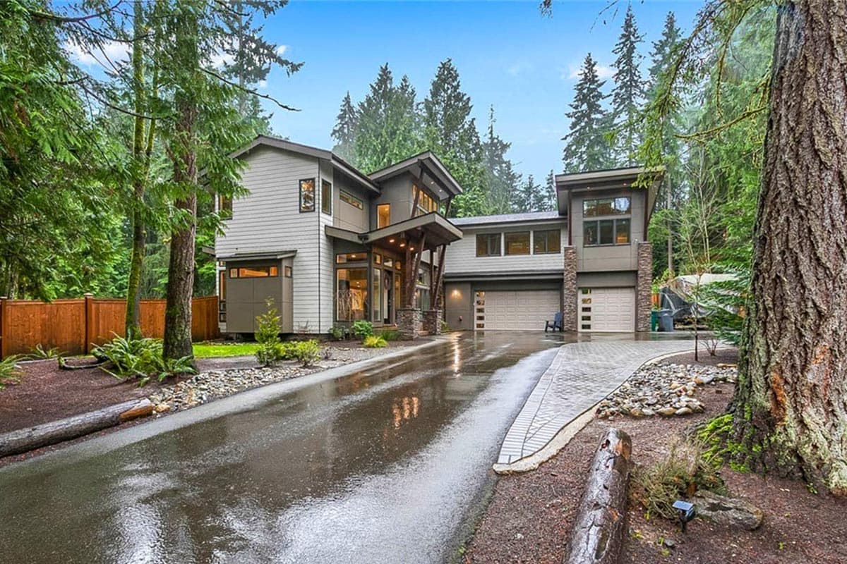 Modern house plan exterior with stacked stone accents, cantilevered rooflines, and a three-car garage.