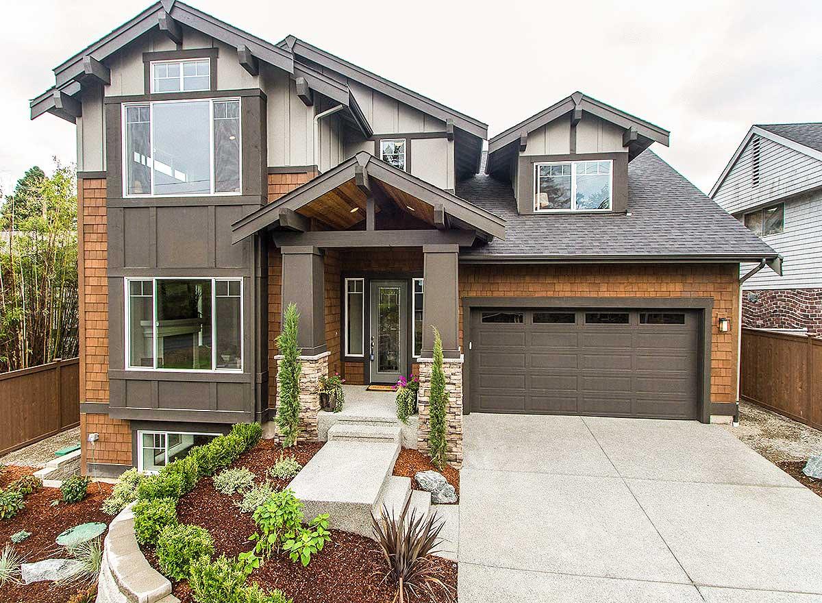 Craftsman style house plan exterior with multiple gables, exposed rafter tails, covered entryway, and attached garage.