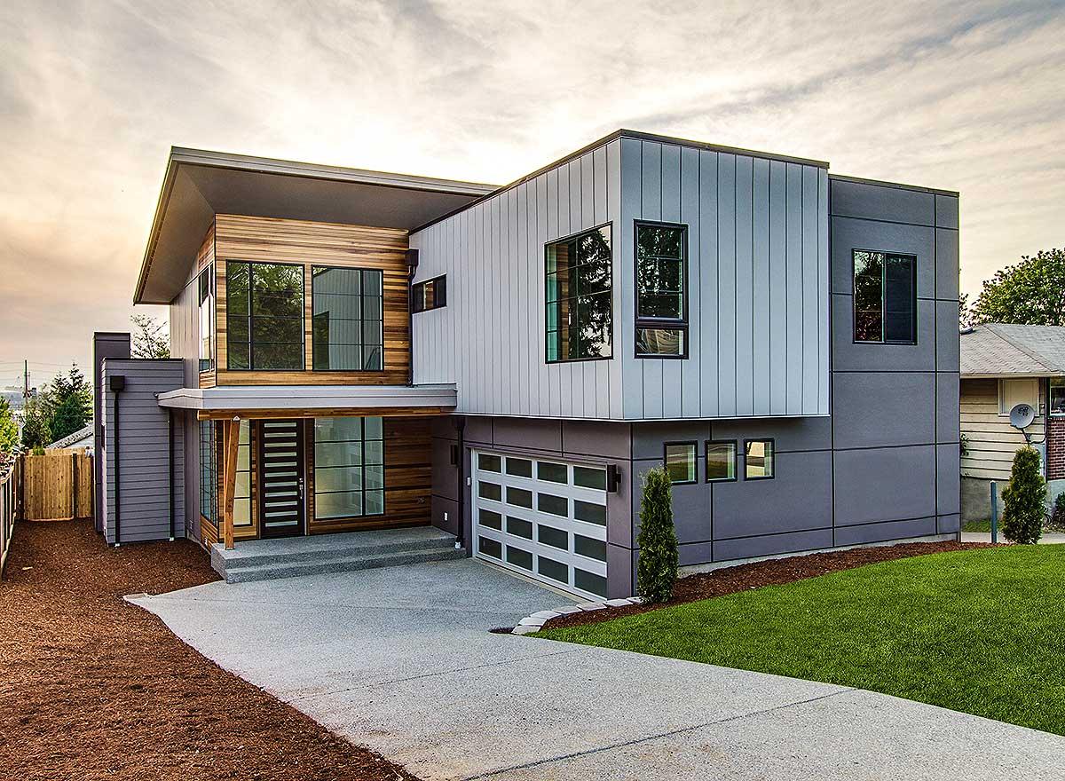 Modern house plan exterior with a cantilevered second story, wood and metal siding, and a glass garage door.