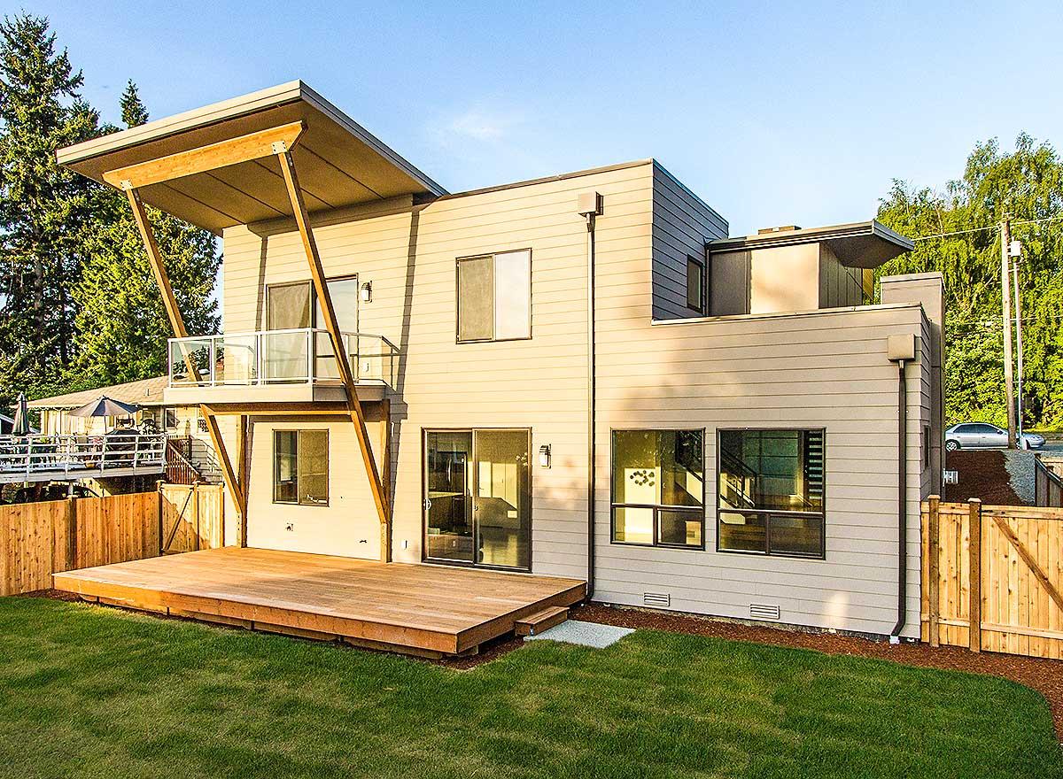 Modern house plan exterior with cantilevers, upper balcony, large wood deck, and horizontal siding.