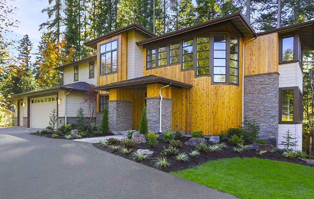 Modern house plan exterior with wood siding, stone accents, a covered entry, and a three-car garage.