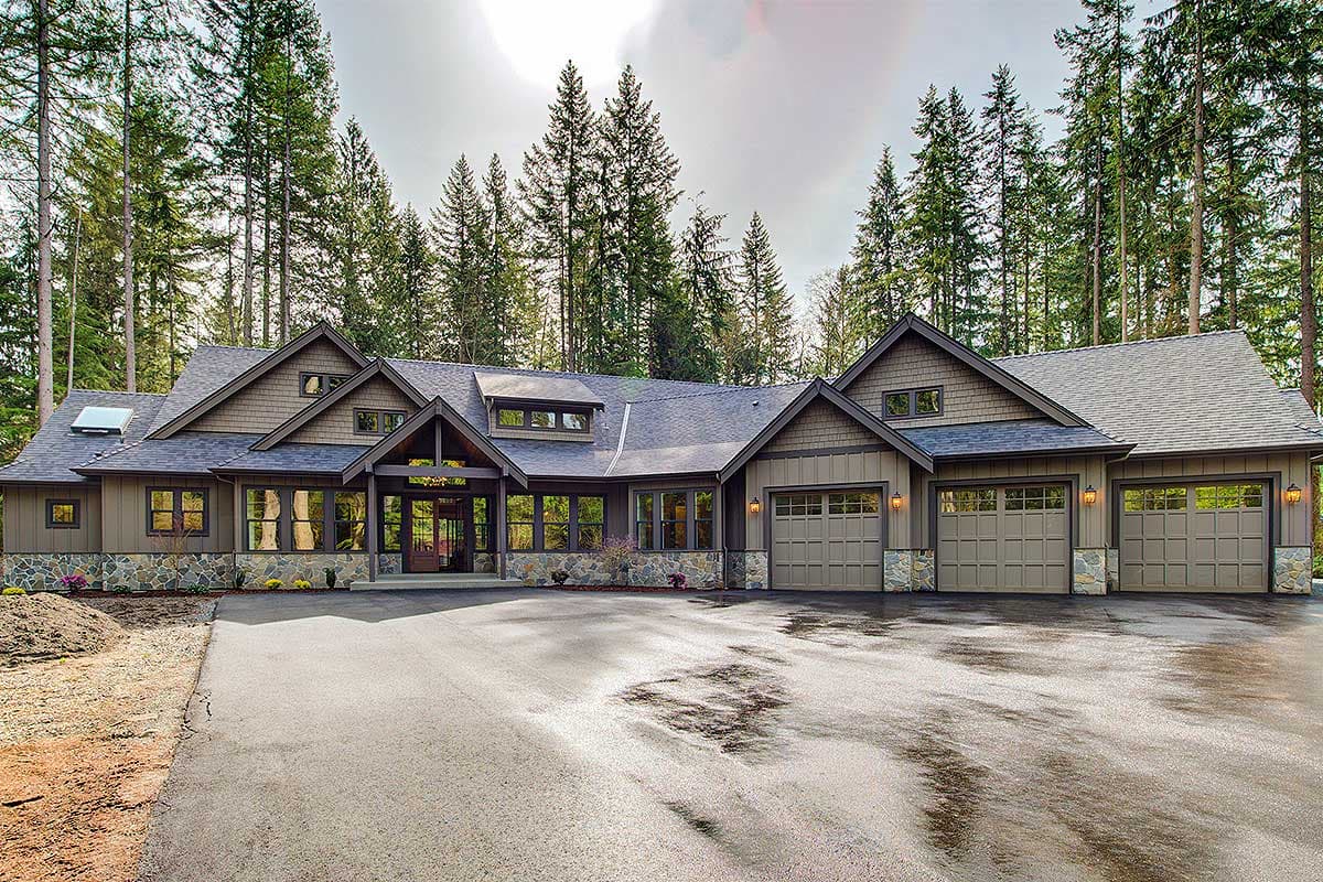 House plan exterior: Modern Ranch style, one story, with a covered entry, stone accents, and a three-car garage.