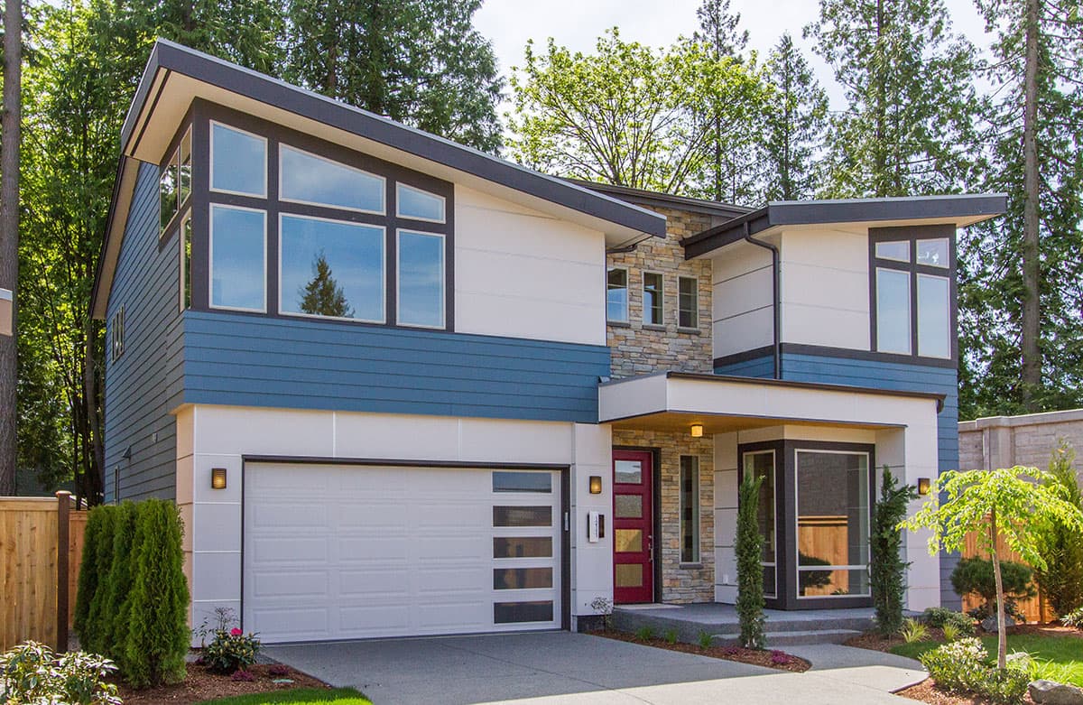 Modern two-story house plan exterior with cantilevered rooflines, large windows, stone accents, and blue siding.