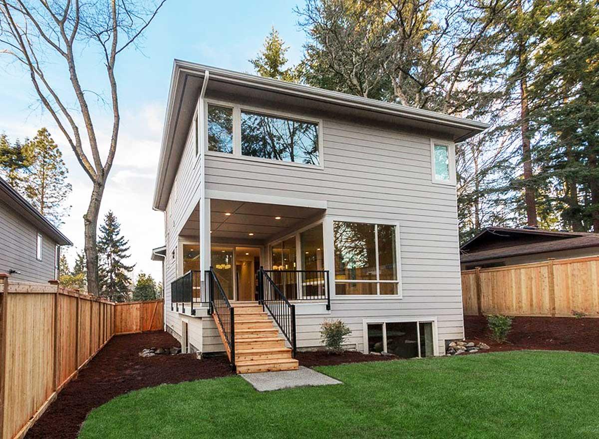 Modern two-story house plan exterior with covered porch, large windows, and side entrance stairs.