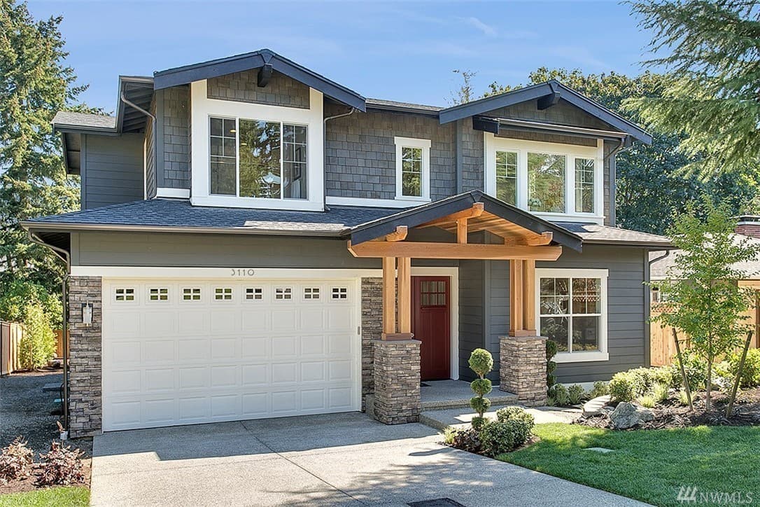 House plan exterior. Two-story Craftsman home with a gable roof, covered porch with exposed beams, and a two-car garage.