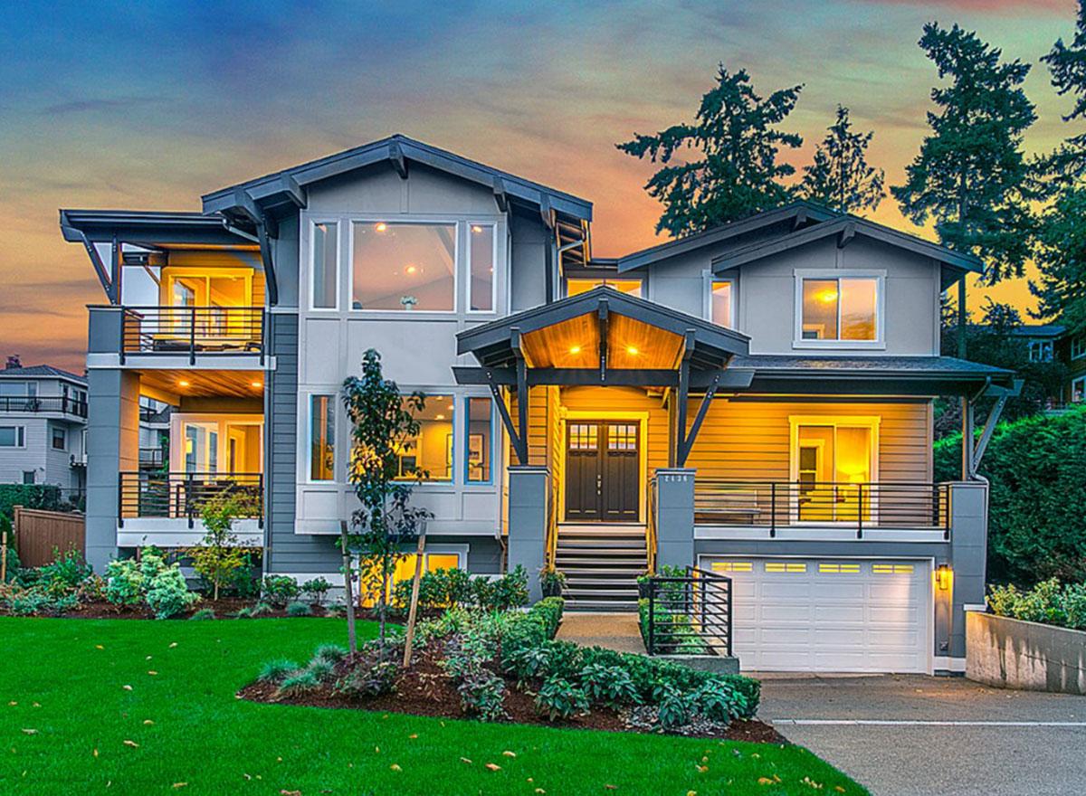 Modern house plan exterior with multiple stories, a covered entry porch, balconies, and a three-car garage.