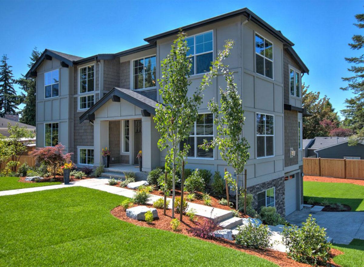 House plan exterior: Three-story Modern Farmhouse with gabled entrance, multiple dormers, and a side-facing garage.