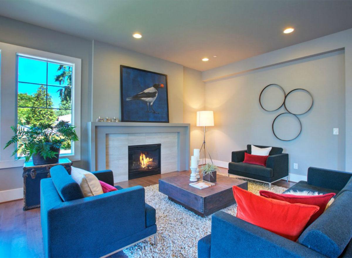 Interior view: Living room with fireplace, large window, two sofas, coffee table, and floor lamp.
