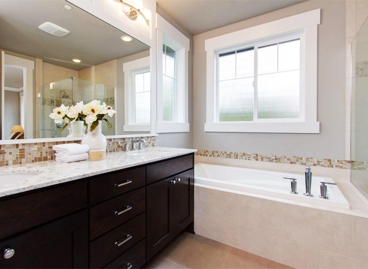 Bathroom interior with double vanity, soaking tub, and glass-enclosed shower.