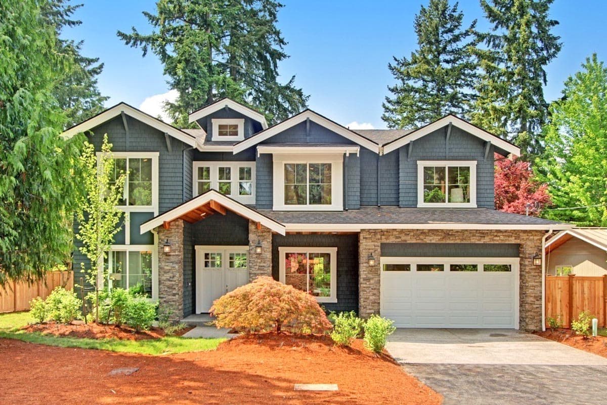 House plan exterior. Two-story Craftsman style home with gables, stone accents, multiple windows, and a two-car garage.