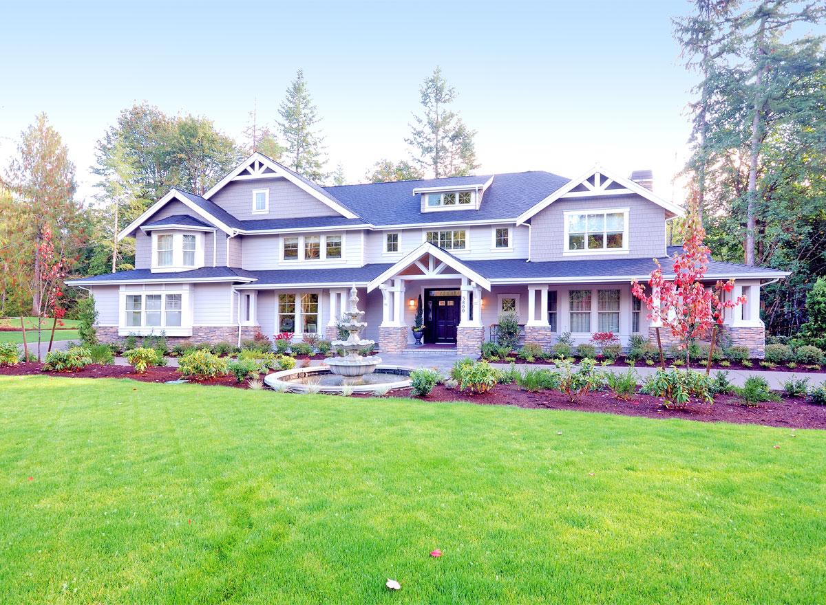 Craftsman style house plan exterior, two stories, with a covered porch, dormers, and stone accents.