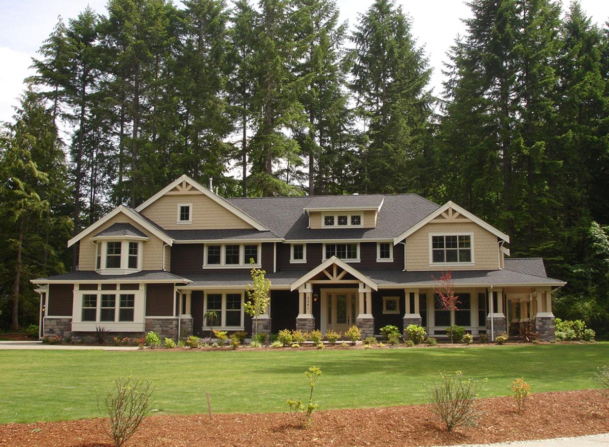 House plan exterior: two-story home with gables, dormers, a covered porch, and bay windows.