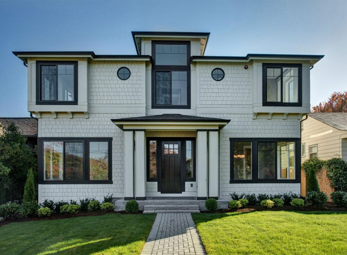 Two-story house plan exterior with shingle siding, multiple gables, prominent portico, and dark-framed windows.