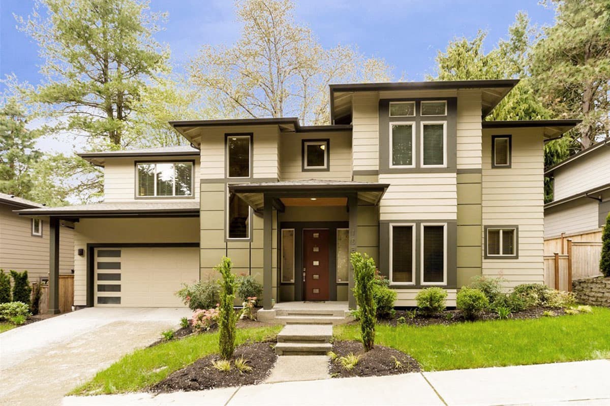 Modern two-story house plan exterior with a covered entryway, attached garage, multiple gables, and horizontal siding.