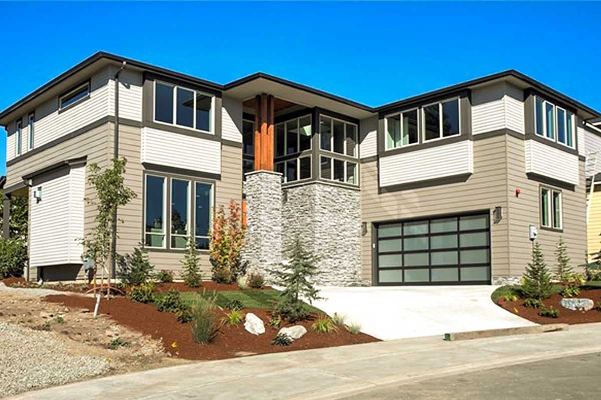 Modern house plan exterior with two stories, stone accents, large windows, and a glass garage door.