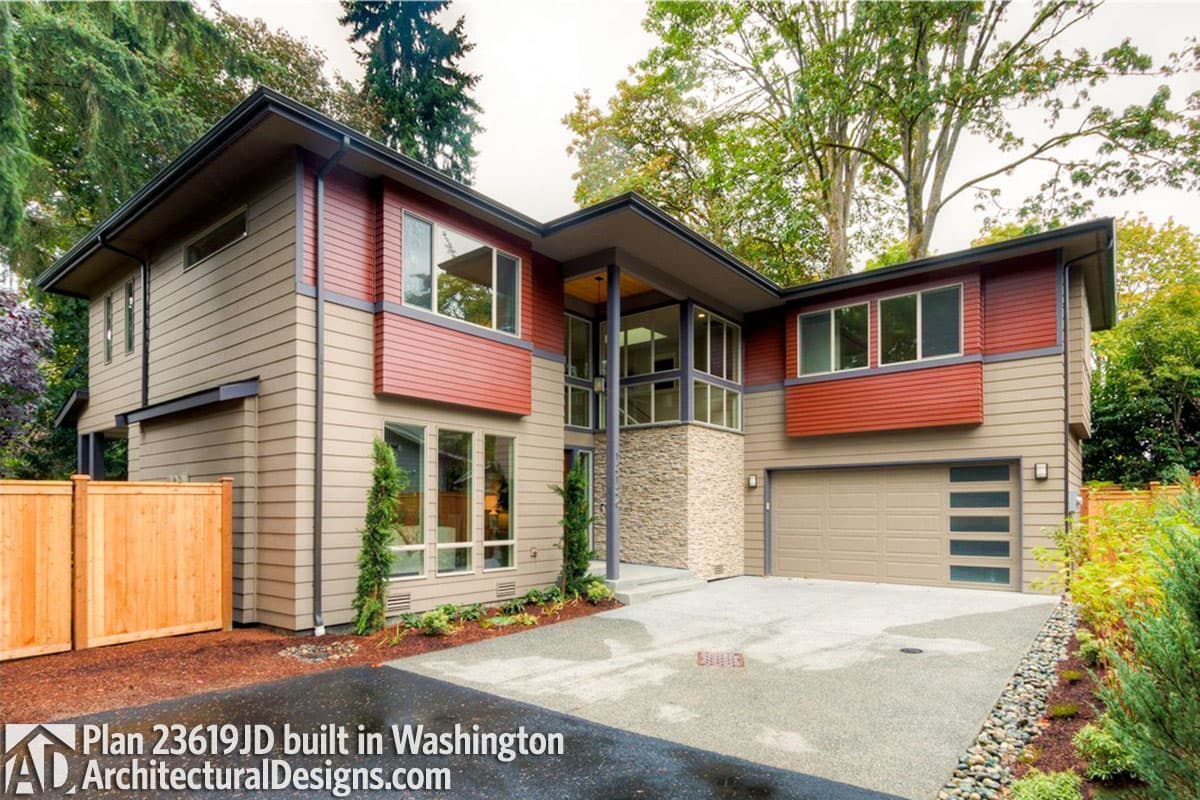 Modern two-story house plan exterior with horizontal siding, stone accents, prominent rooflines, and a two-car garage.