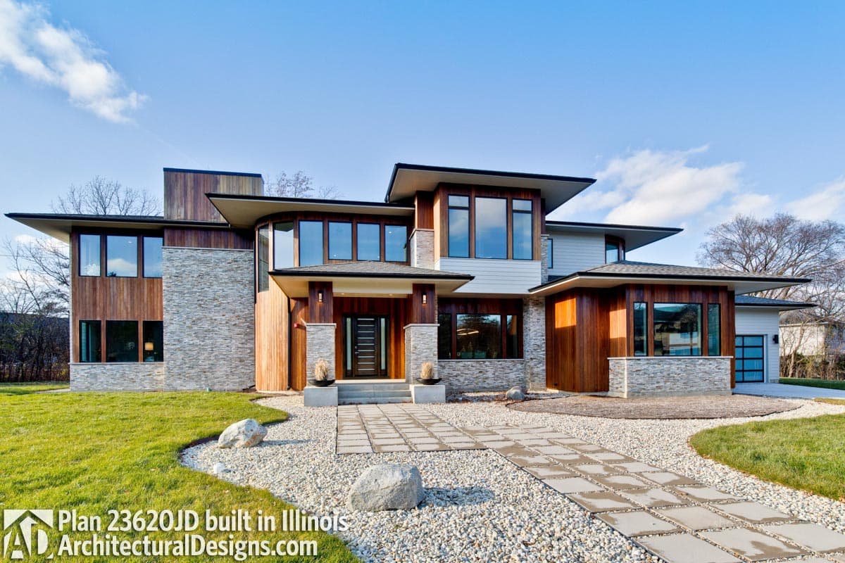 Modern house plan exterior with wood and stone facade, multi-level rooflines, large windows, and covered entry.