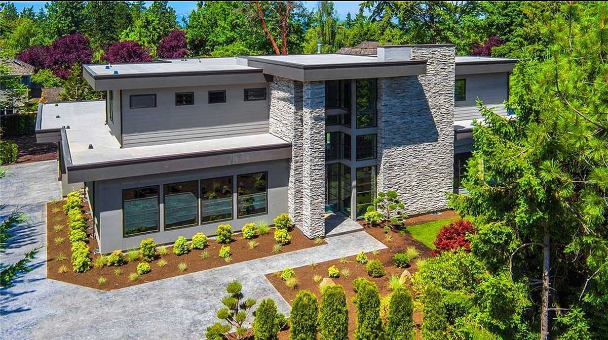 Modern house plan exterior with flat rooflines, stone accent wall, and multiple large windows.