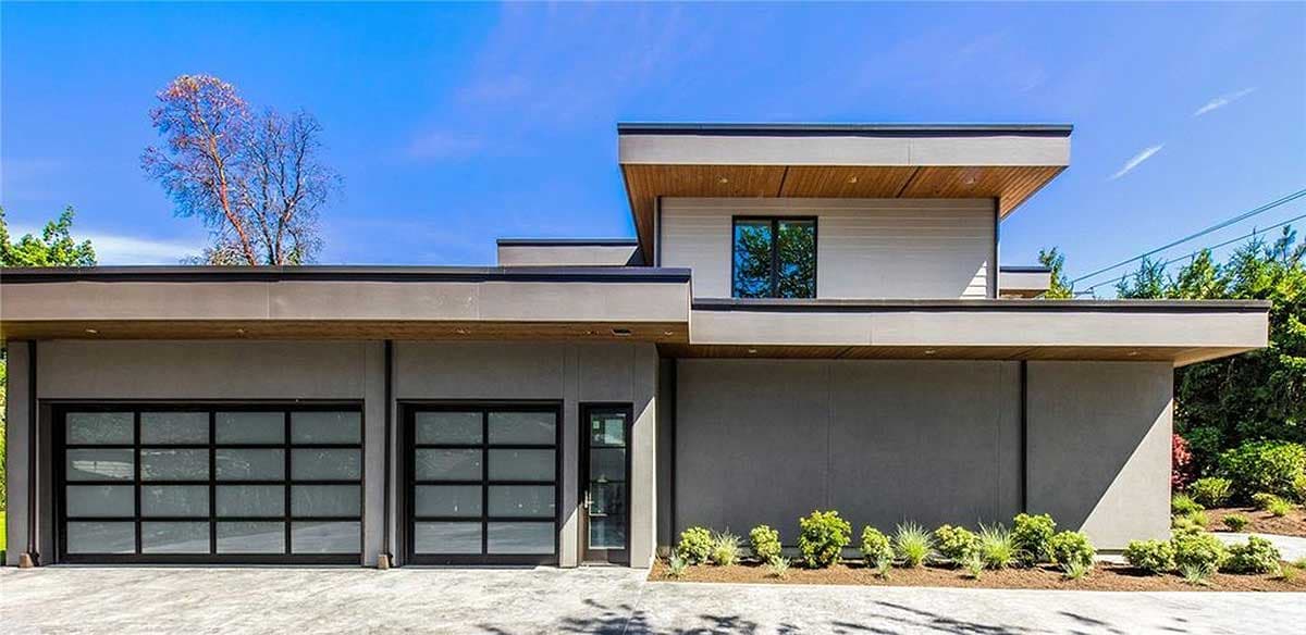 Modern house plan exterior with two glass garage doors, flat rooflines, and wood soffits.