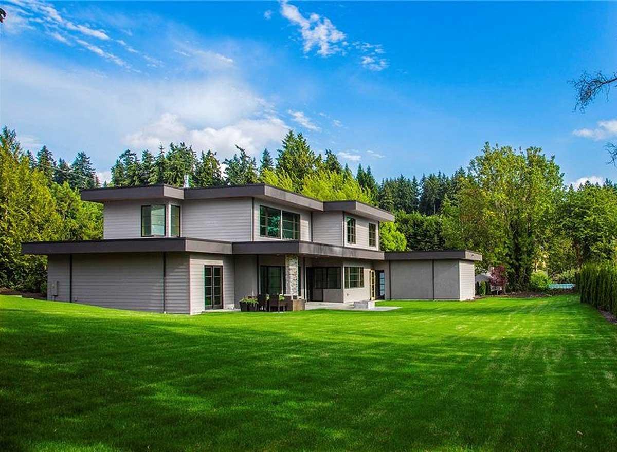 Modern two-story house plan exterior with horizontal siding, flat rooflines, large windows, and a detached garage.