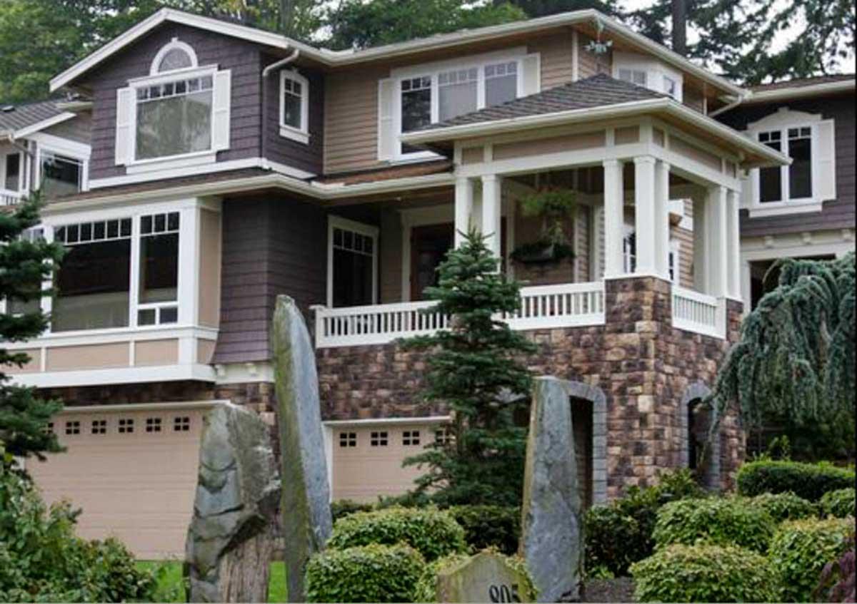 House plan exterior with stone base, covered porch with columns, multiple gables, and diverse window styles.
