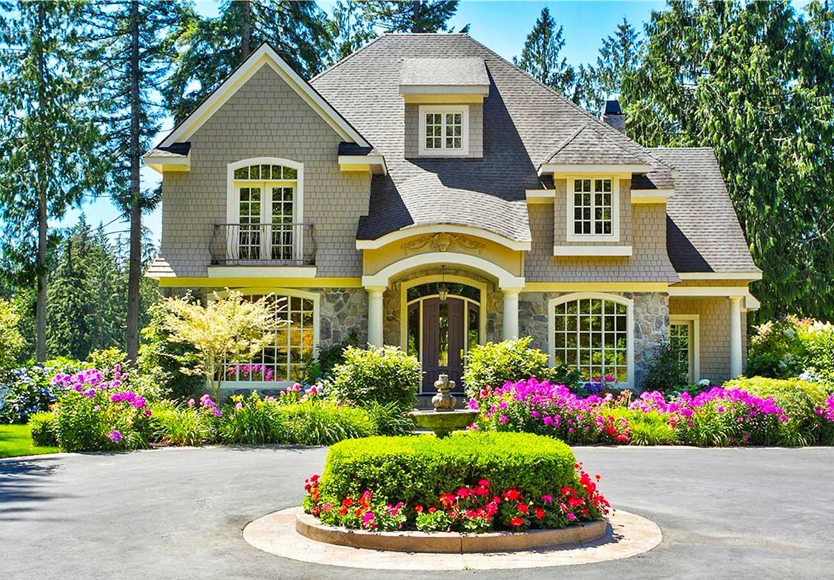 House plan exterior: Two-story home with shingle siding, stone accents, arched entryway, dormer window, and a small balcony.