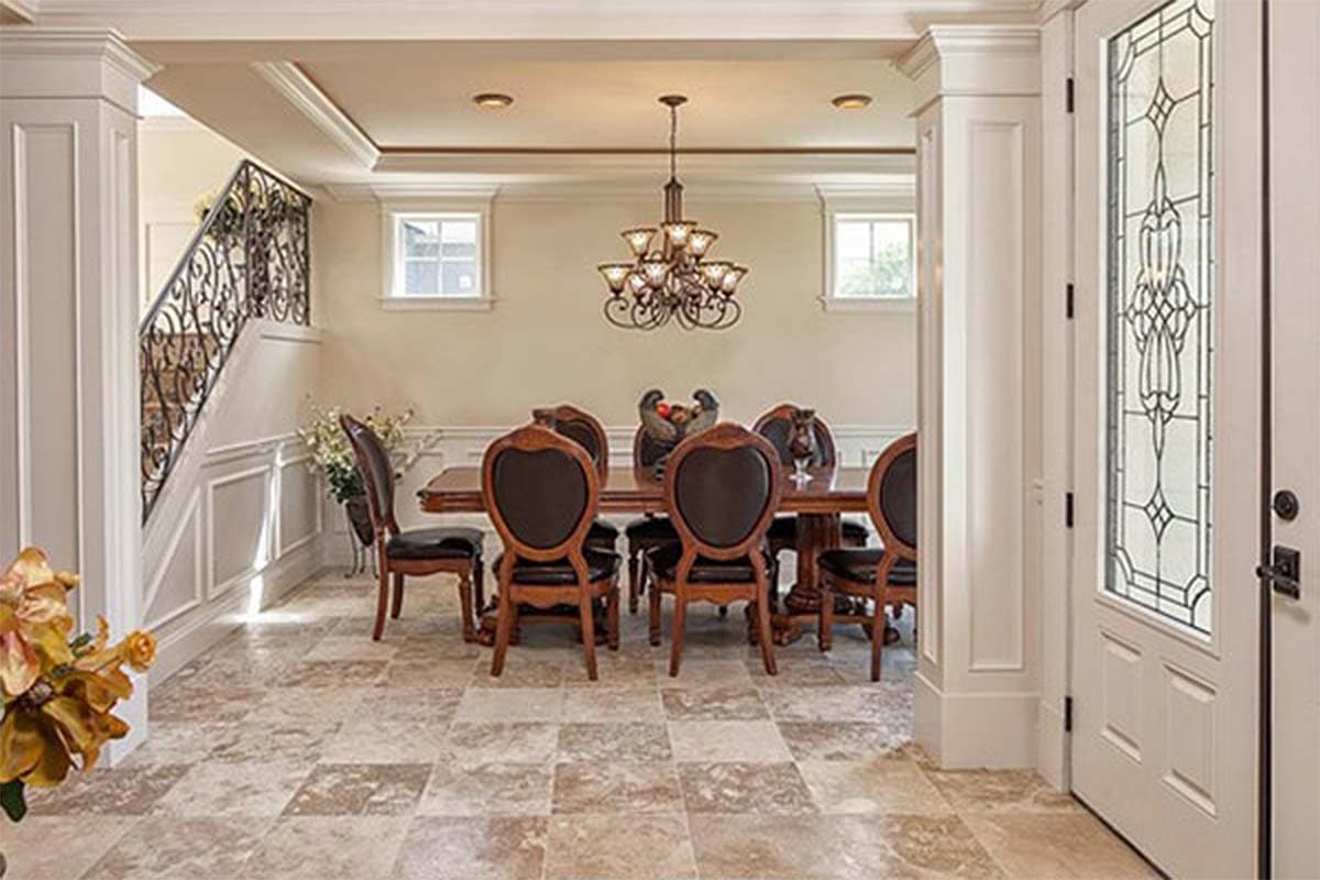 Interior view of dining room with wrought iron stair railing, crown molding, and decorative glass door.