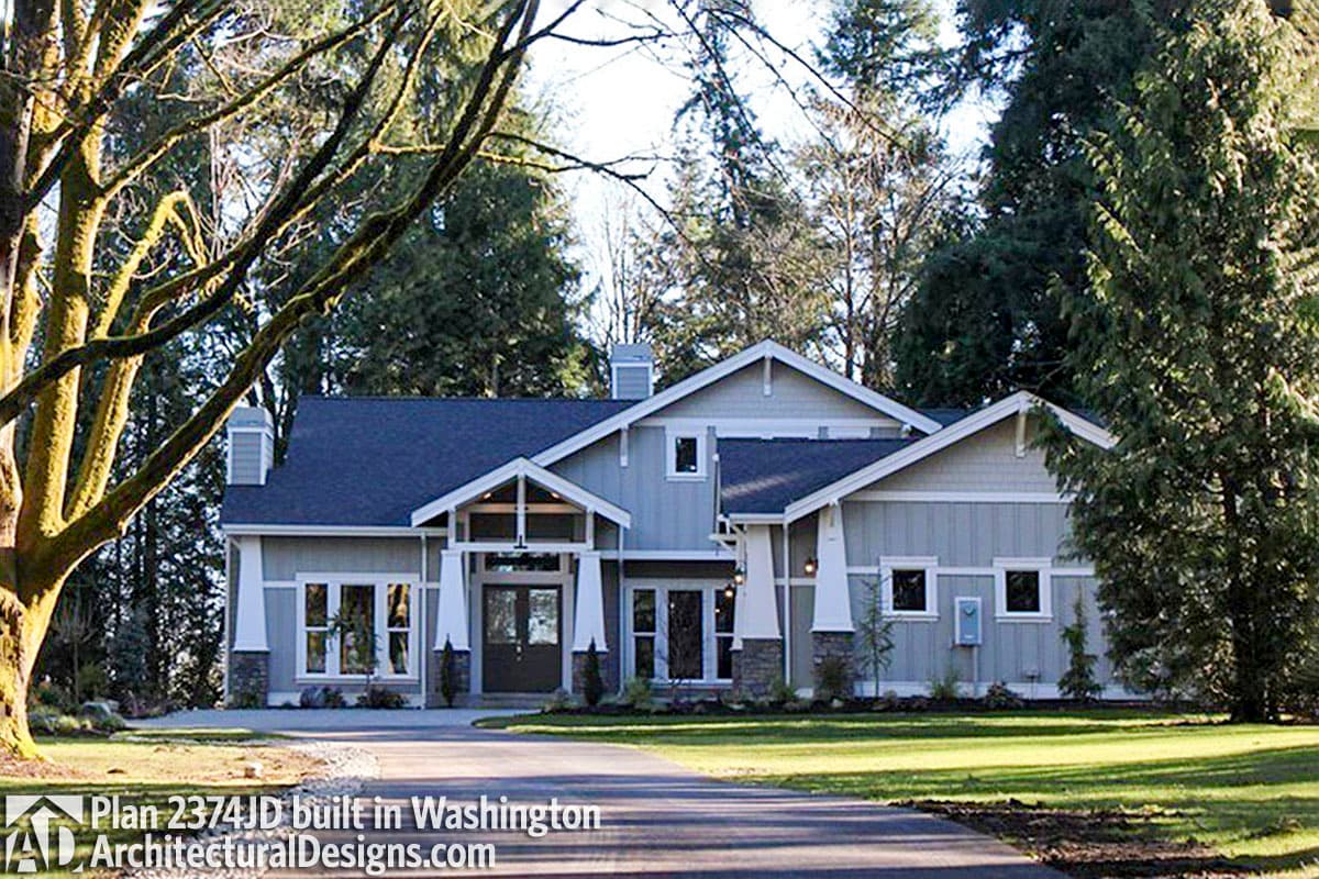 House plan exterior: Modern Craftsman style, two stories, prominent gabled entrance, stone accents, and varied rooflines.