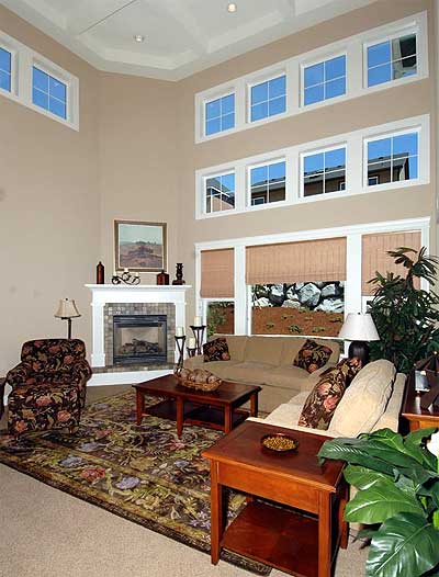 Great room interior with vaulted ceiling, fireplace, and a wall of windows.
