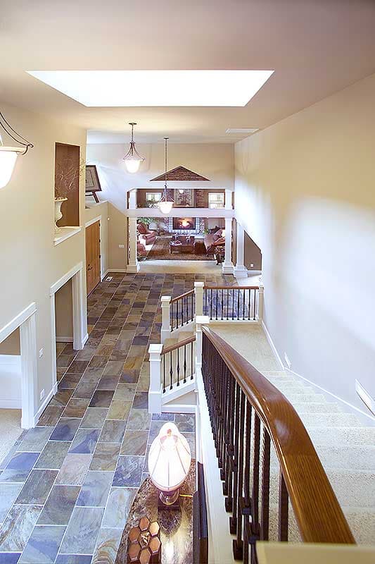 Interior view of a house with a vaulted ceiling, skylight, and multi-level living areas visible.