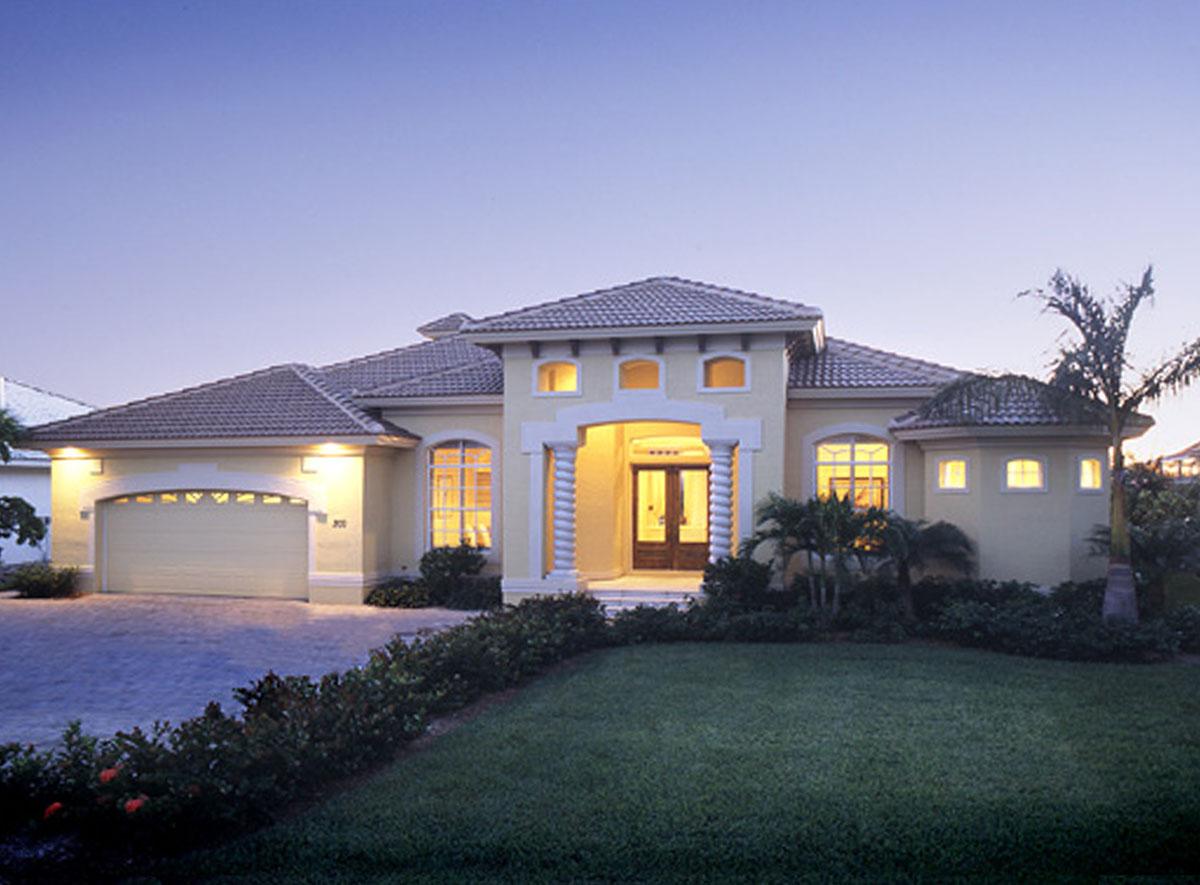 House plan exterior. One-story Mediterranean style. Features include arched entry, barrel tile roof, arched windows, and attached garage.