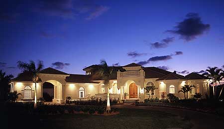 House plan exterior of a two-story Mediterranean-style home with arched entryways, multiple gables, and a central balcony.