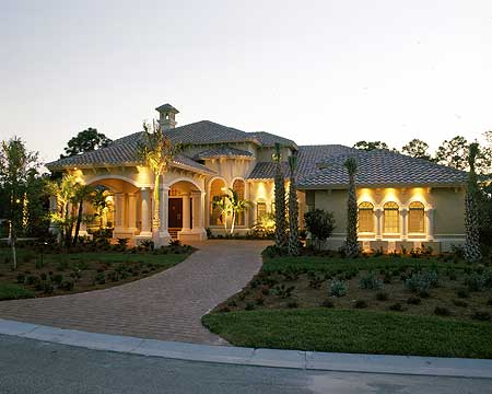 House plan exterior with a stucco finish, tile roof, arched windows, and a covered entryway with columns.