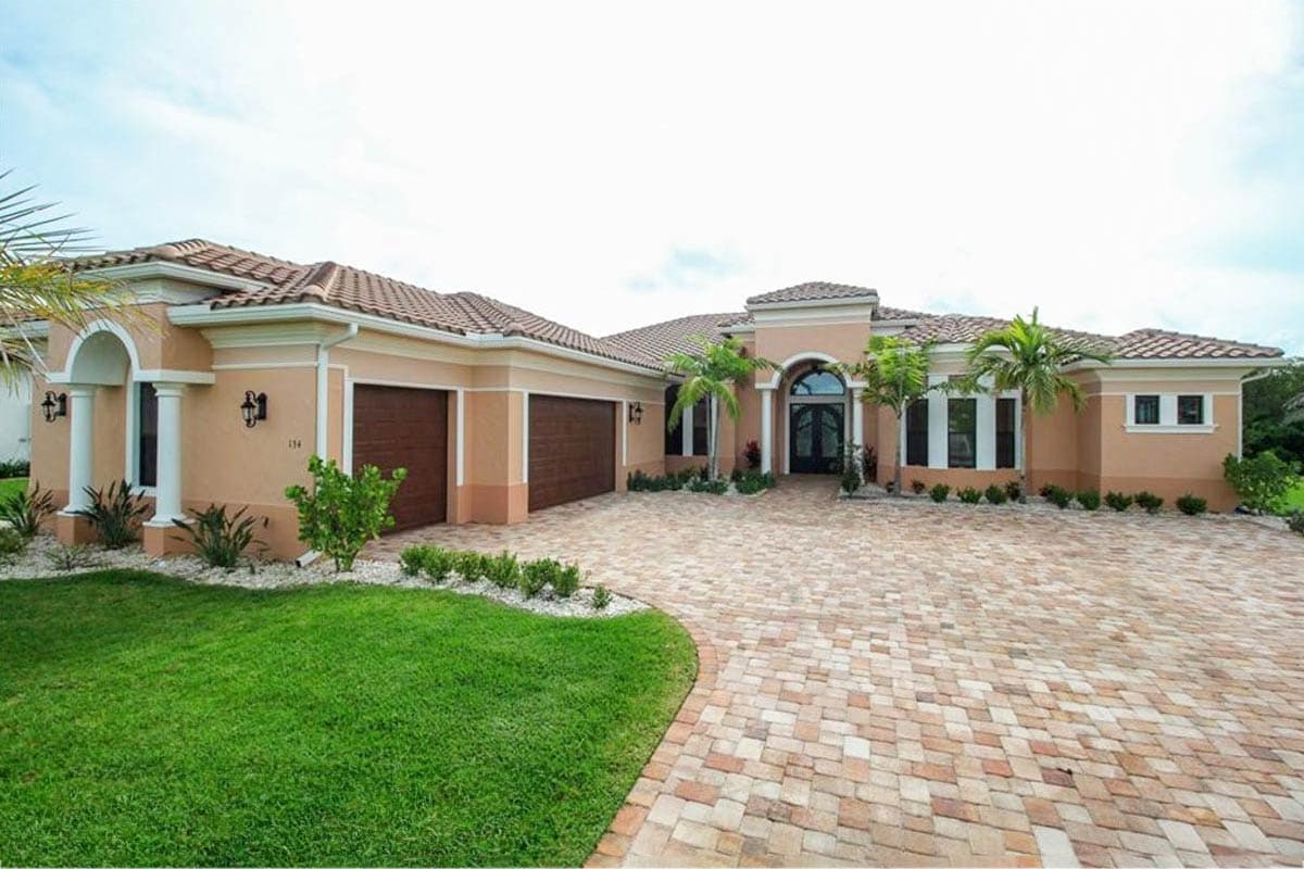 House plan exterior. One-story Mediterranean style. Features include arched entryway, barrel tile roof, and attached garage with two bays.