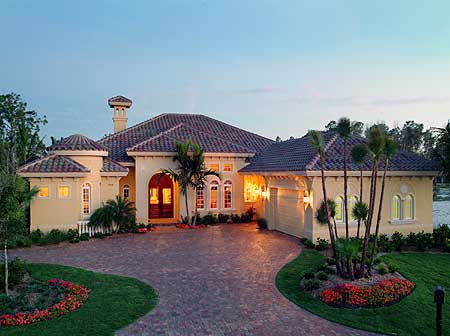 House plan exterior: Mediterranean style, single-story, arched entryway, round turret, tile roof, attached garage.