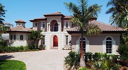 Two-story Mediterranean style house plan exterior with arched windows, balustrade balcony, and tiled roof.