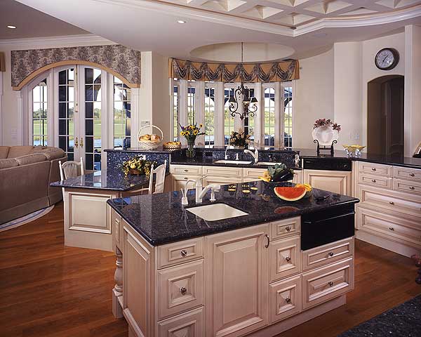 Kitchen with granite countertops, center island with sink, and French doors. Coffered ceiling detail is visible.