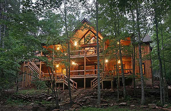 Log cabin house plan exterior with multiple decks and a prominent gable with large windows.
