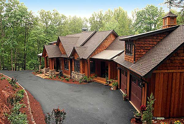 House plan exterior with multi-level rooflines, stone accents, covered entryway, and attached three-car garage.
